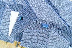 Construction roof of new house is being covered asphalt shingles while building