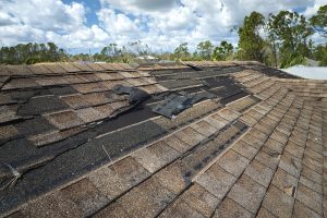 Damaged house roof with missing shingles 